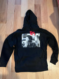 Black hoodie with a graphic design on a wooden floor